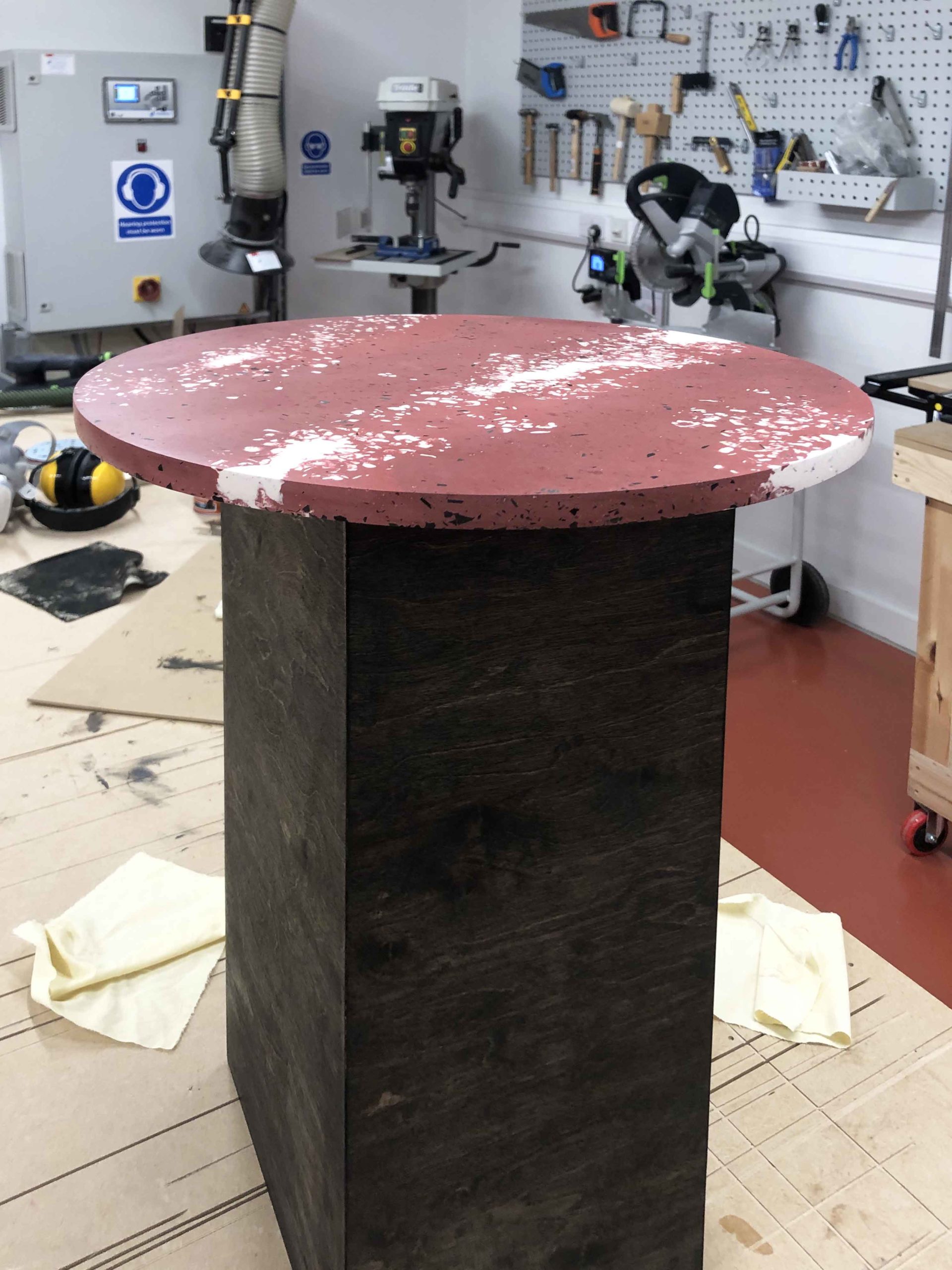 Spared - a round table with a red top made from plastic waste.